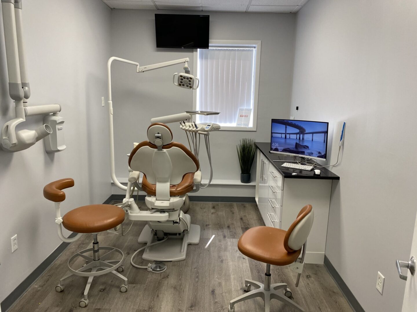 A dentist 's office with two chairs and a computer.