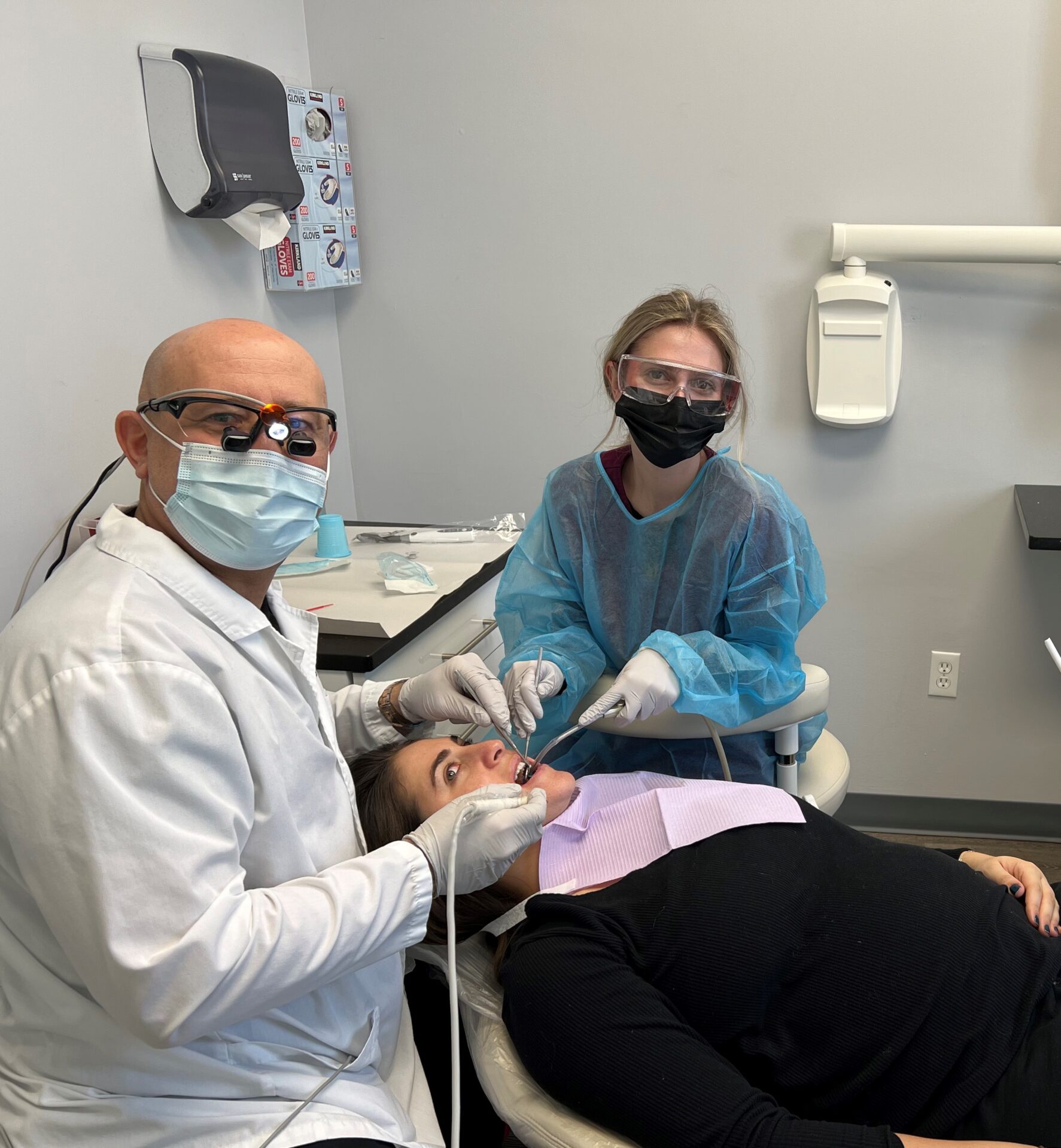 A dentist and two assistants in an office.
